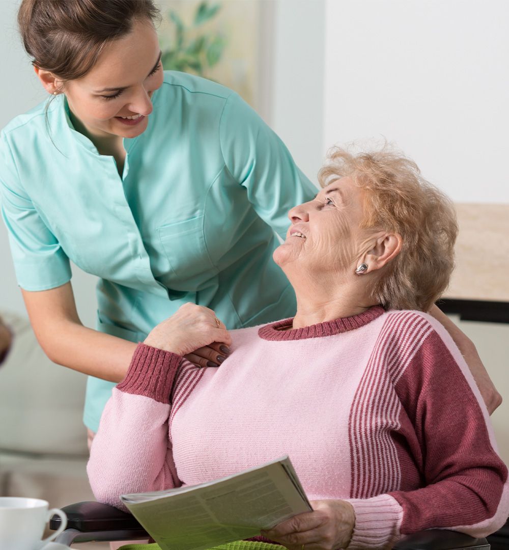 Mitarbeiterin kümmert sich um eine ältere Dame bevor es Essen gibt